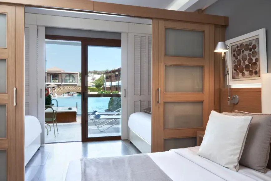 atlantica-holiday-village-rhodes-family-room-sliding-door-swim-up-pool-view-with-outdoor-whirlpool_13764